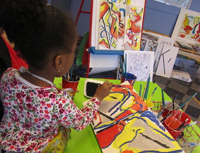 A young artist painting her DeKooning inspired piece on canvas. 