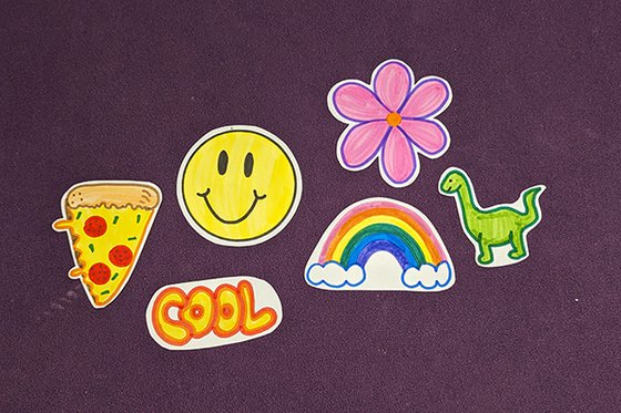 Six colorful stickers featuring pizza slice, word "cool,"  smiley face, rainbow, pink daisy and dinosaur.