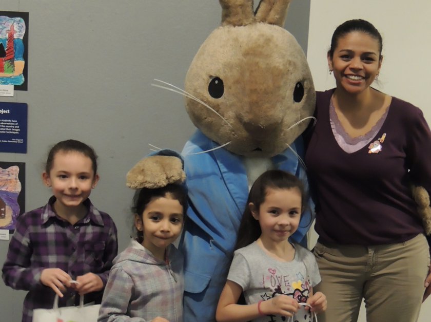 Family standing next to Easter Bunny. 