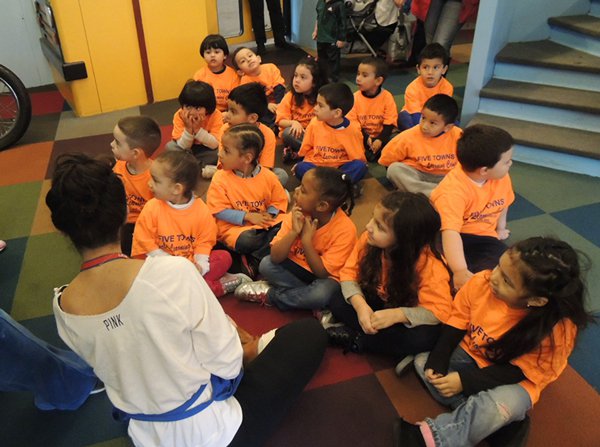 Group of campers in exhibit sitting around an LICM educator. 