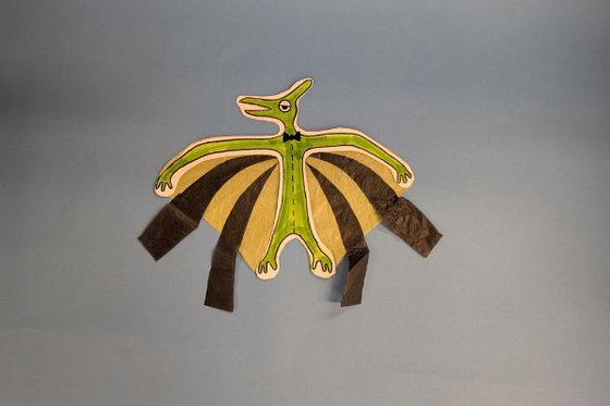 green and yellow paper dinosaur craft set against a blue background.