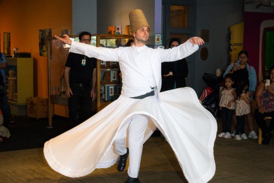 A dervish in a traditional white outfit performs on the LICM second floor. 