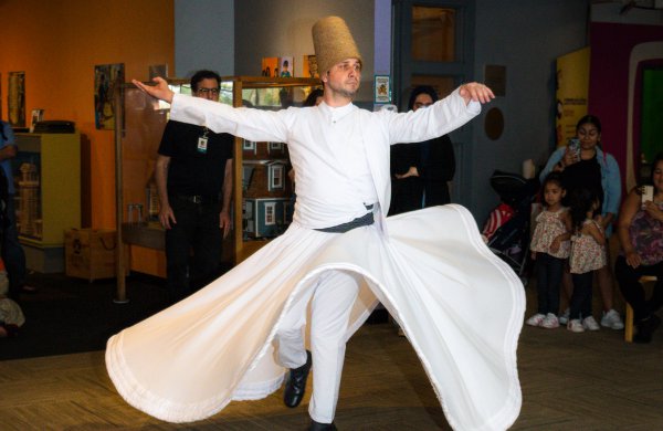 A dervish in a traditional white outfit performs on the LICM second floor. 