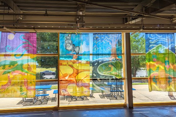 Four lage paintings on silks featuring nature landscapes hanging in LICM's outter lobby windows. 