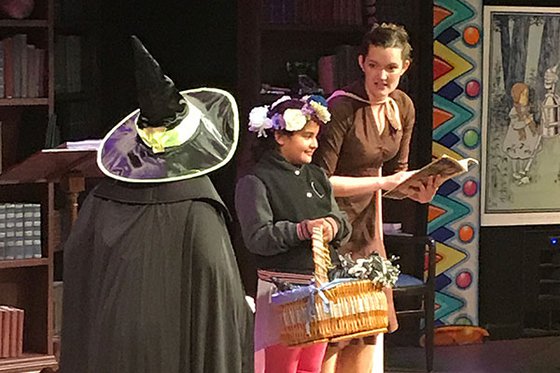 Two characters on stage with an audience member on stage in the play A Journey to Oz. 