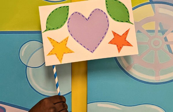 A paper small flag decorated with color stars, a heart and leaves. 