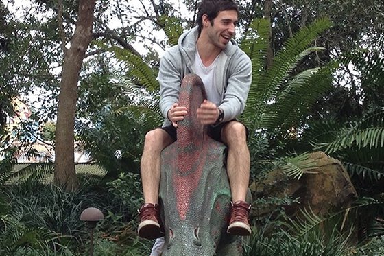 The Dino Whisperer sitting on top of a mechanical parasaurolophus dinosaur. 