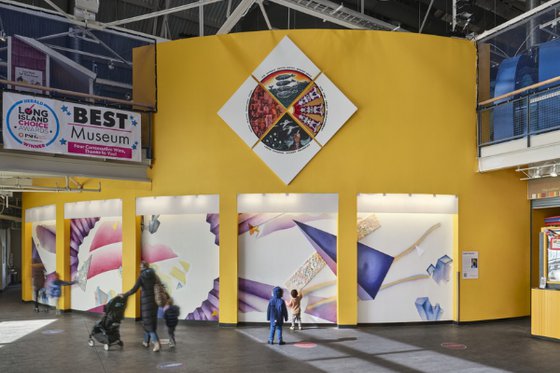 Wide view of the LICM Outer Lobby showing geometric art on white bay walls. Photo by Garrott Carroll