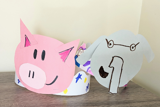 A pink paper hat of Piggie and a grey paper hat of Elephant from Elephant and Piggie. 
