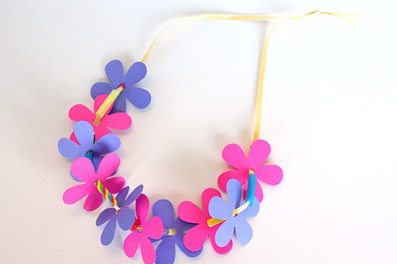 A necklace constructed with paper colorful flowers, beads and ribbon. 