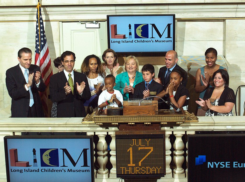 Members of Museum board, staff and children posing for picture at Stock Exchange. 