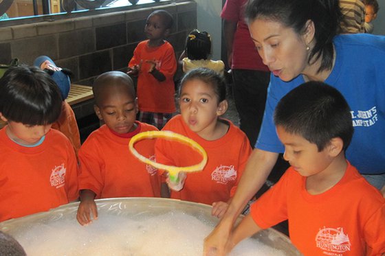 Campers and counselor making bubbles at museum
