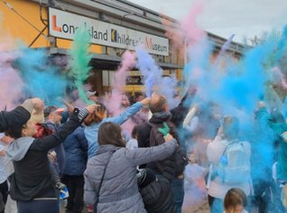 Group of people spraying colors in front of Long Island Children's Museum