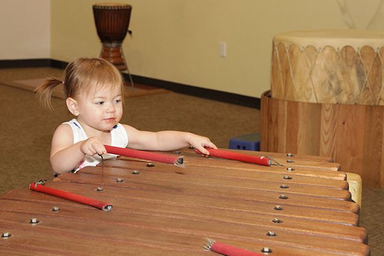 Toddle playing a large xylophone in exhibit. 