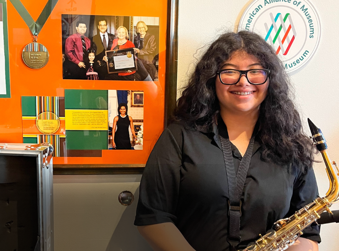Photo of Ruth holding a Saxophone.