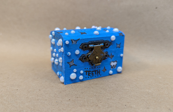 A small wooden box with a clasp painted blue decorated with pearls. 