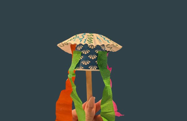 Paper jellyfish made of a small cup, popsicle stick, streamers and mini coffee filter. 