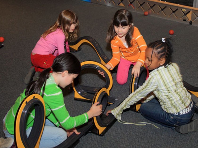 A group of girls working together to create rollercoaster arcs. 