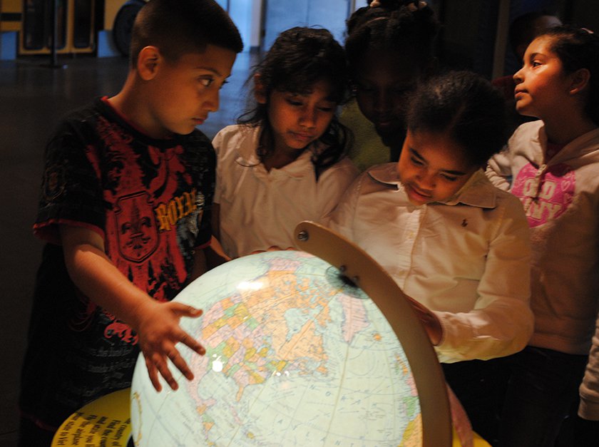 Visitors looking at a globe of the world. 