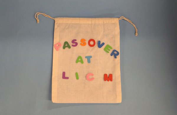 A small canvas drawstring bag decorated with foam letters reading "Passover at LICM." 