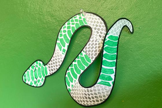 A paper snake with green and silver scales. 