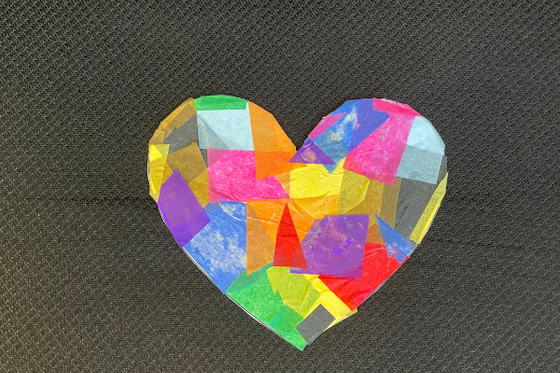A heart covered with a variety of colored tissue paper. 