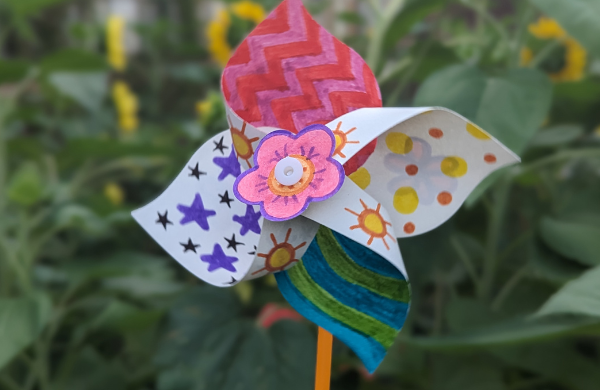 A white pinwheel decorated with colorful patterns using markers. 
