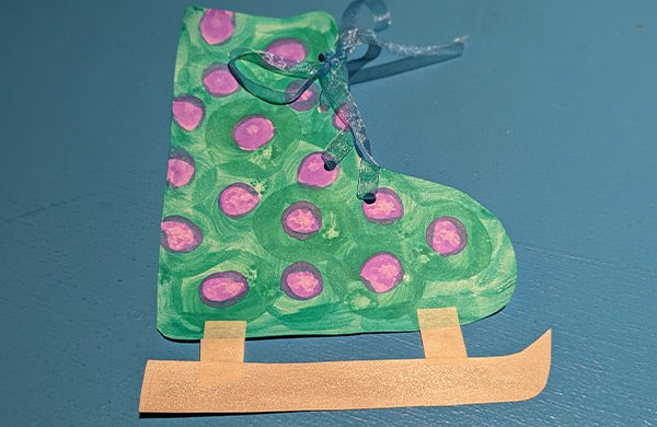 A paper green and purple ice skate with ribbon laces. 