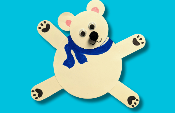 A white paper polar bear with large eyes and a blue scarf. 