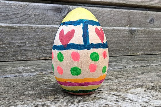 A wooden egg painted with various decorations. 