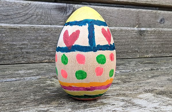 A wooden egg painted with various decorations. 