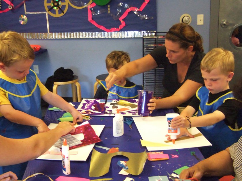 Adult and children complete a craft in Museum during Family Fun Night.