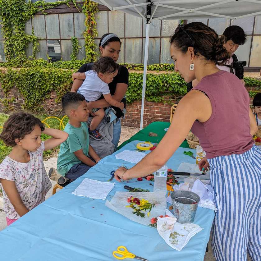 Artist and children creating natural dye from plants