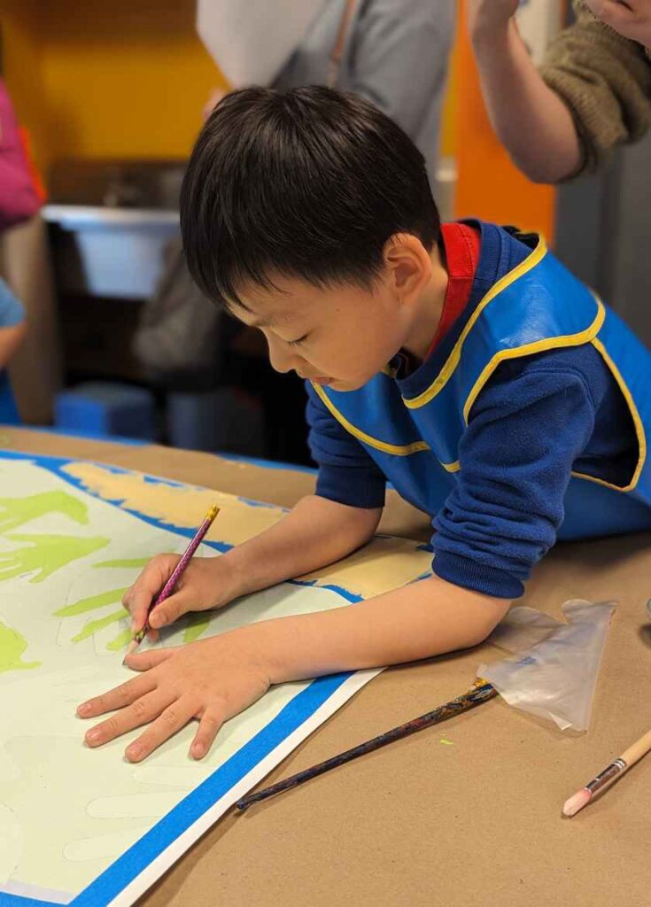 A child painting at the mural paint party