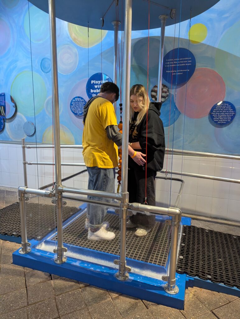 Two adults in Giant Bubble machine
