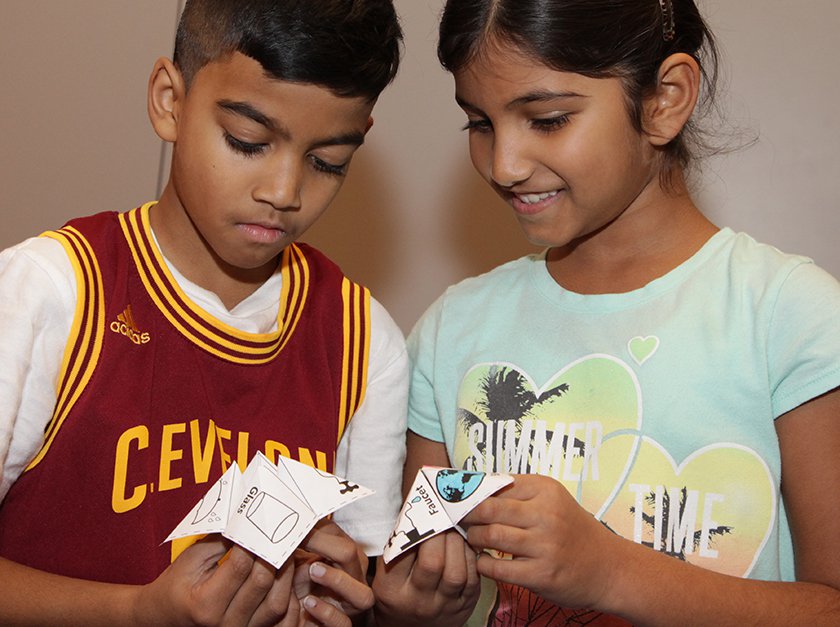 Two children holding hand-made fortune tellers